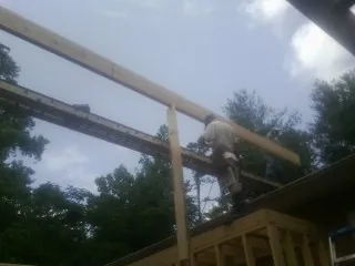 Carpenter setting a ridge beam over a new addition frame — Ice Dam Removal by Roofing Brothers in Dalton