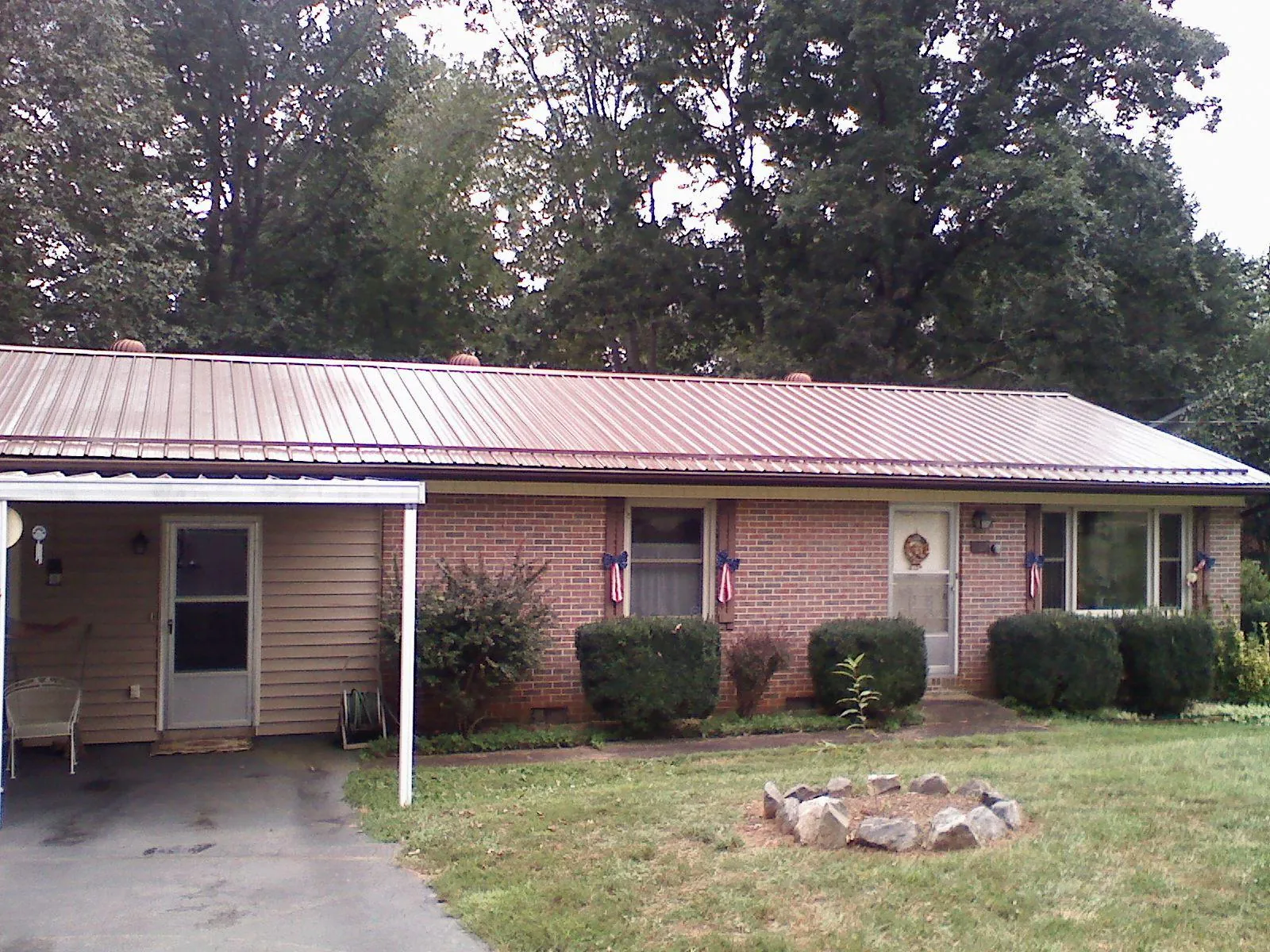 Bronze metal roof and carport on a brick ranch home — Roof Repair work by our crew in Dalton